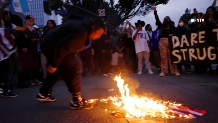 anti-ice-protest-la-man-spits-on-american-flag.jpg